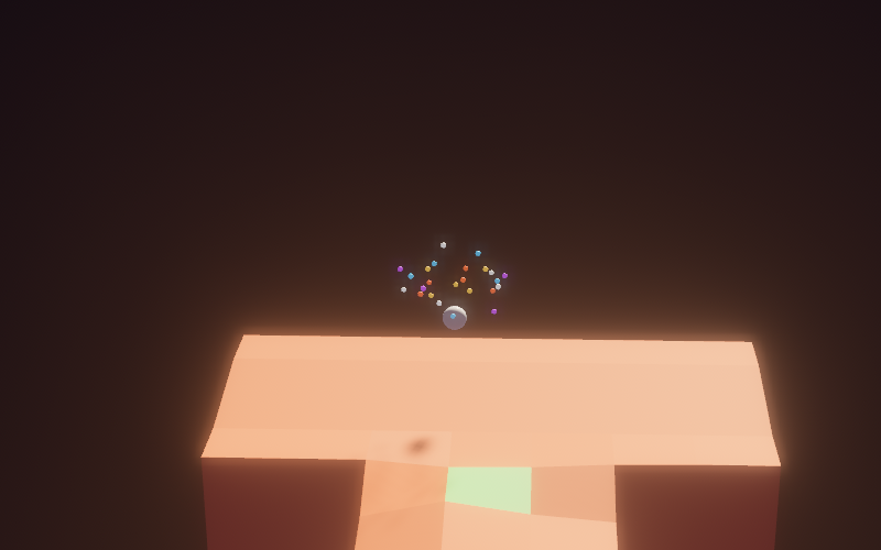 Close crop: a smooth white marble just above an orange platform, surrounded by a loose cloud of tiny gold, cyan, purple and white particles.
